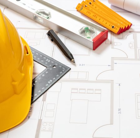 Project blueprints and labor worker hardhat yellow color, Housing project construction, construction site office background.